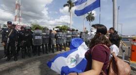 Nicaraguan riot police set up a shield wall as a group of doctors, nurses and medical students protest against the government of President Daniel Ortega, in Managua, Nicaragua, Saturday, Aug. 3, 2019. The Central American nation has been in crisis since April 2018, when protests erupted demanding Ortega's exit from office and early elections, with demonstrators accusing him of consolidating power and ruling in an authoritarian manner. (AP Photo/Alfredo Zuniga)