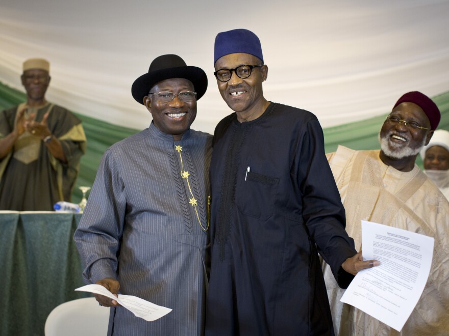 Nigeria's President Goodluck Jonathan, center left, and opposition candidate Gen. Muhammadu Buhari, center right, appear on Thursday in Abuja, the Nigerian capital, after signing a renewal of their pledge to hold peaceful "free, fair, and credible" elections. Fighting broke out after the last time the two men faced off at the polls in 2011.