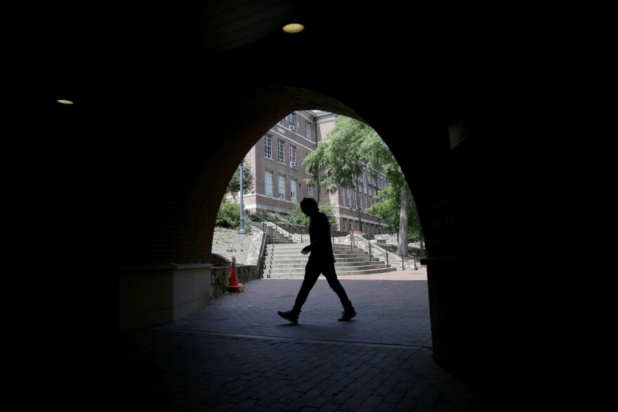 A pedestrian uses a tunnel walkway at the University of North Carolina in Chapel Hill, N.C., Tuesday, June 30, 2020.