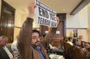 A protester holds up a sign at Bexar County Commissioners Court, March 10, 2026