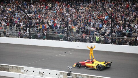 Alex Palou stands on his vehicle to the cheers of the crowd after winning the 109th running of the Indianapolis 500,