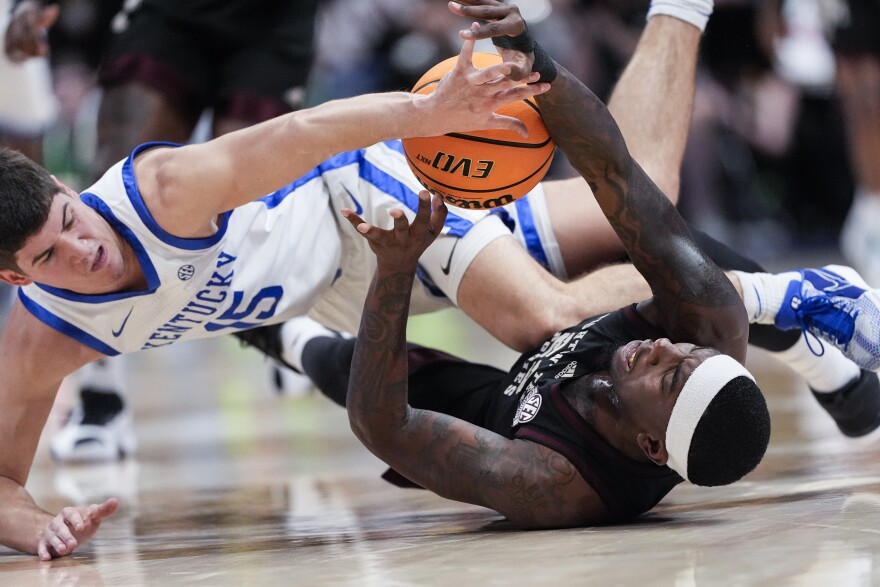 Kentucky guard Reed Sheppard (15) and Texas A&M guard Tyrece Radford (23) fight for a loosse ball during the first half of an NCAA college basketball game at the Southeastern Conference tournament Friday, March 15, 2024, in Nashville, Tenn. (AP Photo/John Bazemore)