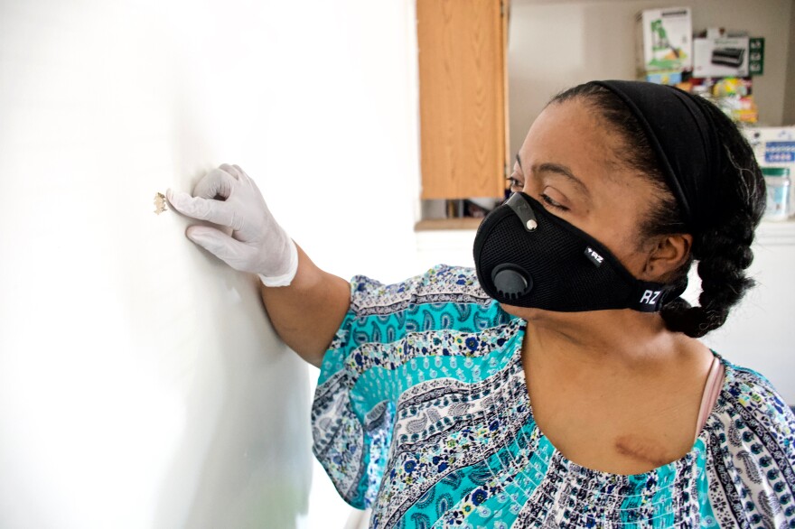 Kim Daniel shows where a bullet fired from a nearby apartment entered her unit. May 2020