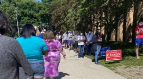 Voters stand in line waiting to vote outside of the Broad Ripple High School building.