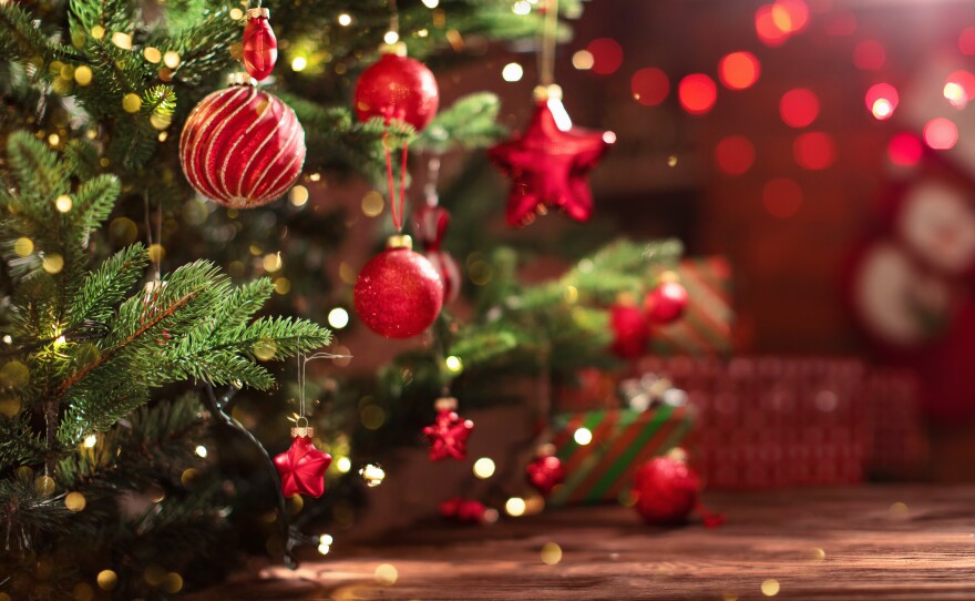 This stock photo shows a decorated Christmas tree near a fireplace.