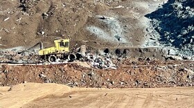 A landfill compactor pushes trash for the first time into the new geothermal cell.