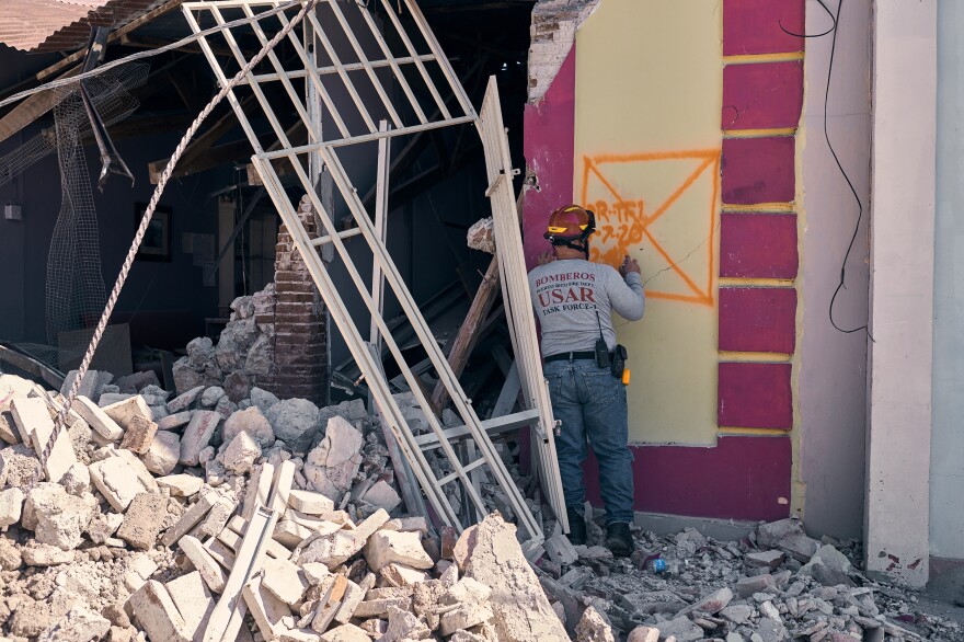 A firefighter searches a building that was severely damaged in Guanica after Tuesday's earthquake.