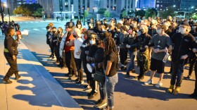 Kansas City attorney Stacy Shaw gives out instructions and protocol to "team red" members Wednesday night in front of police headquarters. Team red protesters were willing to be arrested in case police came for them.