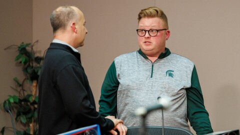 Lansing City Council President Ryan Kost, right, speaks to Lansing Mayor Andy Schor, left, following the conclusion of a Lansing City Council meeting on March 24, 2025.