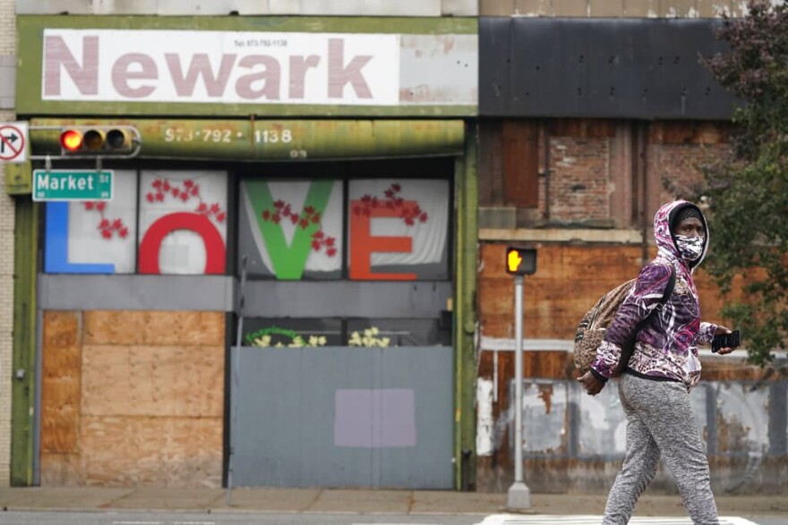 A pedestrian wears a mask as they walk through Newark, N.J., Monday, Oct. 26, 2020.  (AP Photo/Seth Wenig)