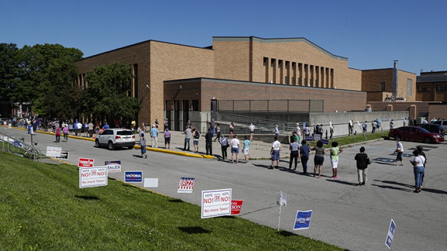 Voters wait in a line outside Broad Ripple High school to vote in the Indiana primary in Indianapolis, Tuesday, June 2, 2020 after coronavirus concerns prompted officials to delay the primary from its original May 5 date. Voters waited up to two hours to cast their ballots. Nearly 550,000 voters requested mail-in ballots, more than 10 times the number of those ballots cast during the 2016 primary.