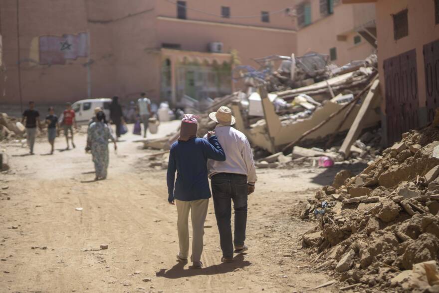 People walk through the wreckage caused by the earthquake, in the town of Amizmiz, near Marrakech, Morocco. An aftershock rattled Moroccans on Sunday as they mourned victims of the nation’s strongest earthquake in more than a century and sought to rescue survivors while soldiers and aid workers raced to reach ruined mountain villages. (Mosa'ab Elshamy/AP)