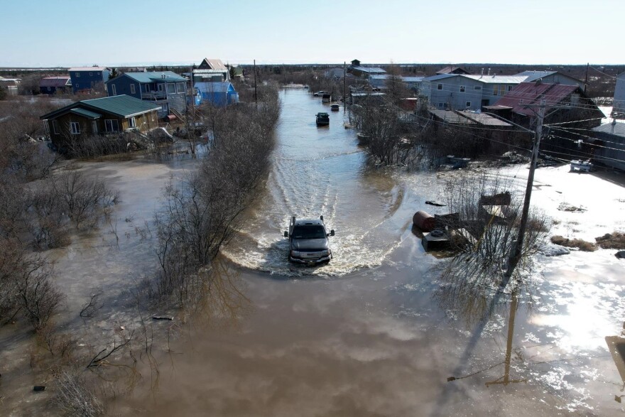 a truck drives through floodwaters
