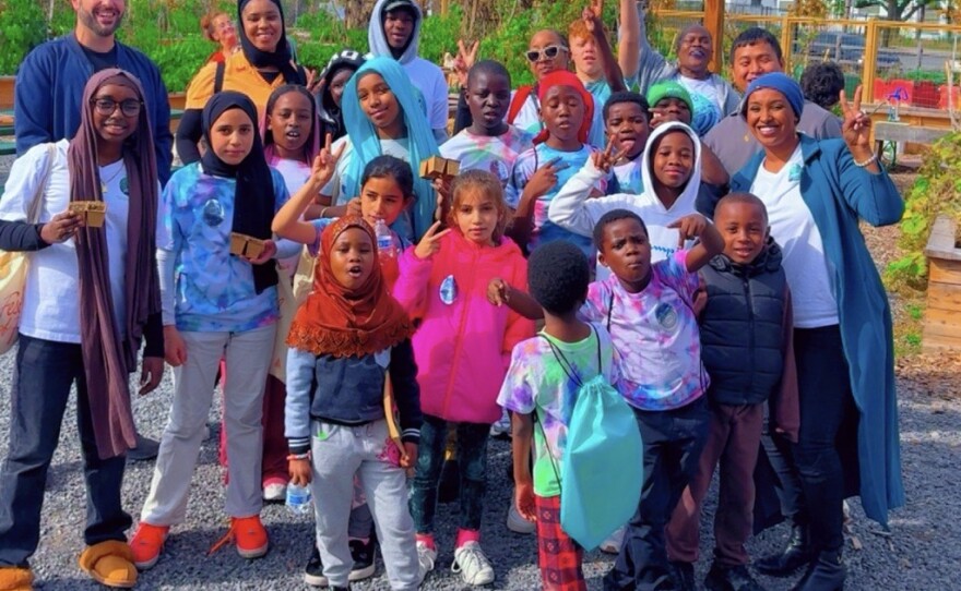 Hani Ali stands amid a group of children whom are a part of her mentorship program.