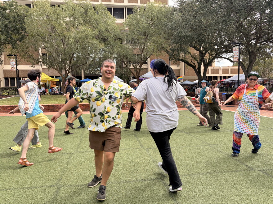 Aldo Garza, the president of the Pride Community Center and event organizer, dances with an attendee on Saturday, Oct. 3, 2026. (Madison Middleton/WUFT News