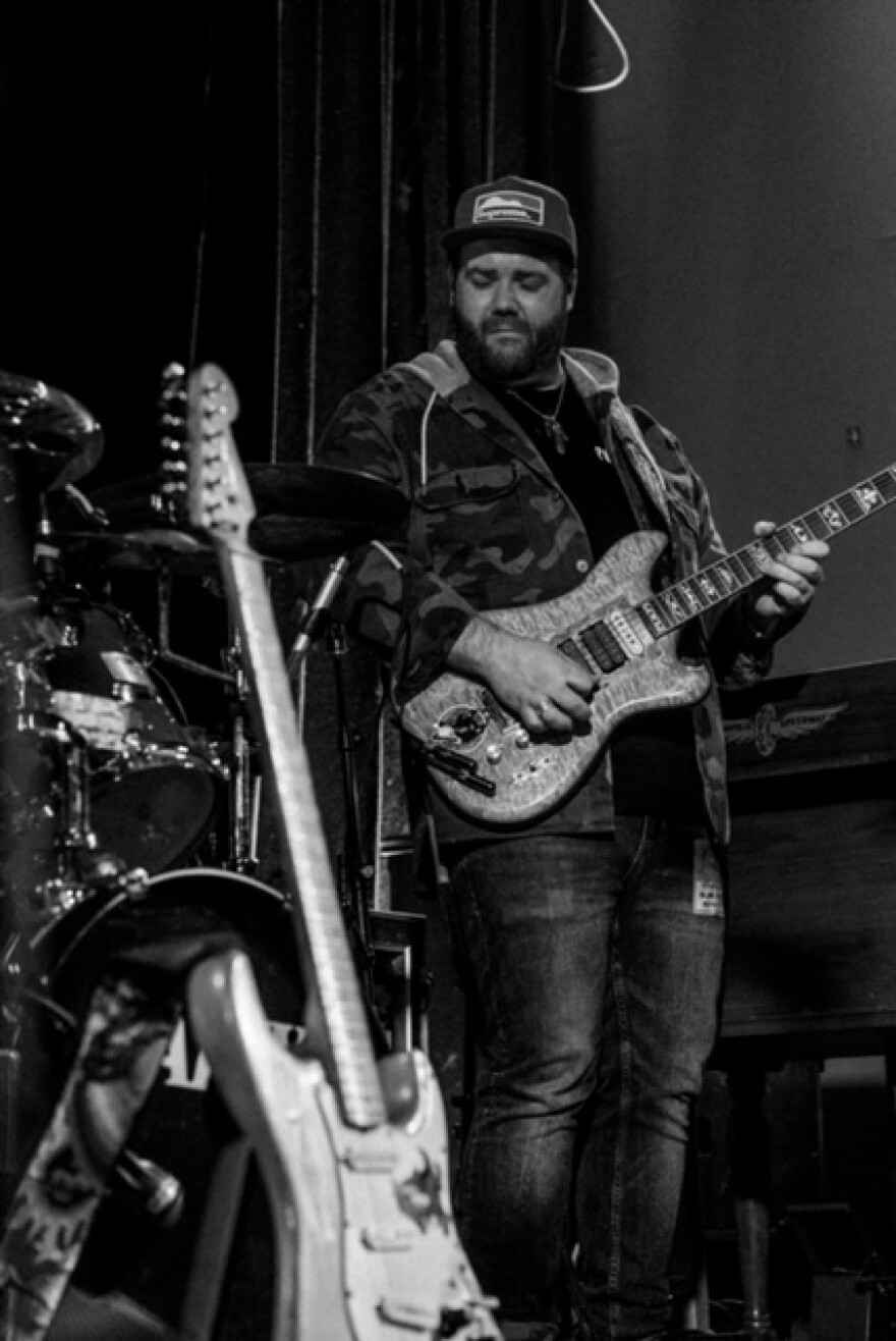 A black and white photo of a man playing a guitar 