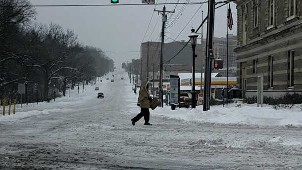 person crosses a snow-covered street