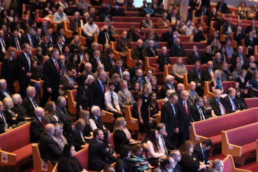 dozens of people fill pews