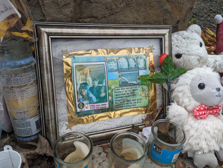  Some stuffed animals, candles and a picture frame laying on the ground. 