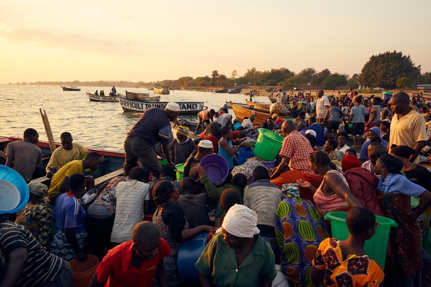 A crowd of fish traders forms around a boat at Lake Malawi laden with usipa, a species of small sardine-like fish that are dried and sold all over the country.
