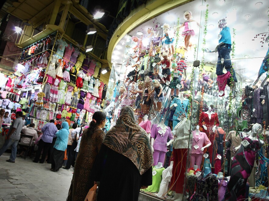 Nighttime shoppers pause to look at a display at Cairo's Ataba market in May 2011. The government says shops must close earlier in order to save scarce electricity, but many Cairo residents are complaining.