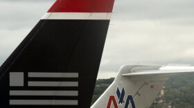 A US Airways jet rests on the tarmac near an American Airlines plane at Ronald Reagan Washington National Airport in Arlington, Virginia.