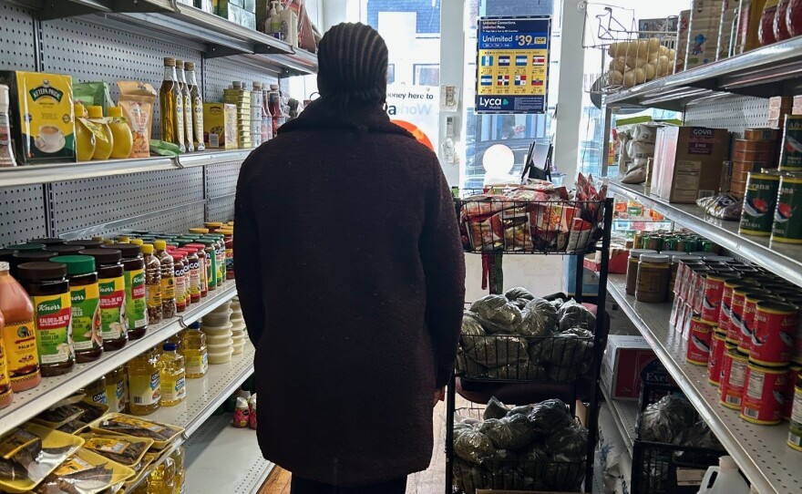 Maria walks the aisles of her market that are empty of customers.