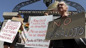 three people holding signs protesting evictions: two are in Spanish, one is in English