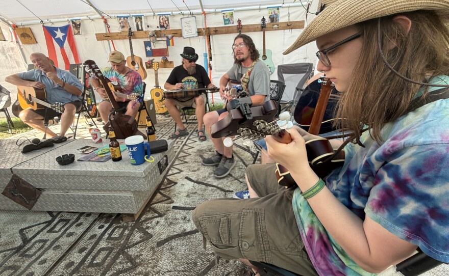 A guitar circle at the Dances With Armadillos campsite includes a mandolin player during the Kerrville Folk Festival.