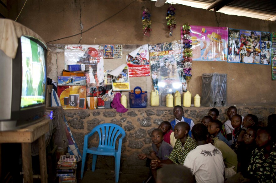 Boys pile into a movie theater that shows Jackie Chan-style action films dubbed in Swahili, in the town of Rutshuru, eastern Congo. The theater offers a brief respite from tensions outside.