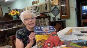 Julie Miller, curator of the Edwards County Historical Society Museum and Sod House Museum, with the famous Saturday Evening Post cover.