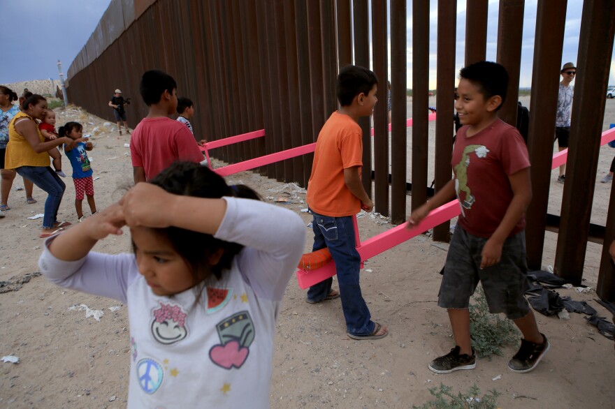 American and Mexican families play with a seesaw installation at the border near Ciudad Juarez, Mexico, in July 2019. London's Design Museum recognized the project with an award for best design of 2020. [Luis Torres / AFP via Getty Images]