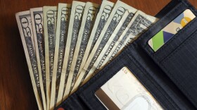 Cash is fanned out from a wallet.