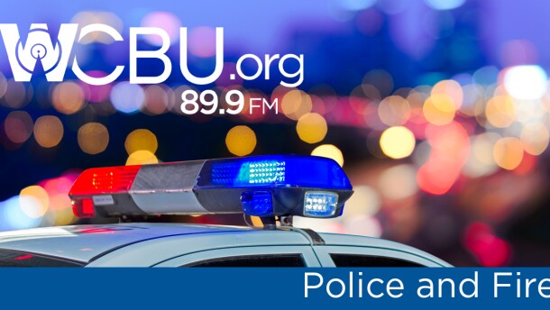 A police car's lights, which are on. The text "WCBU Police and Fire" are laid on top of that photo.