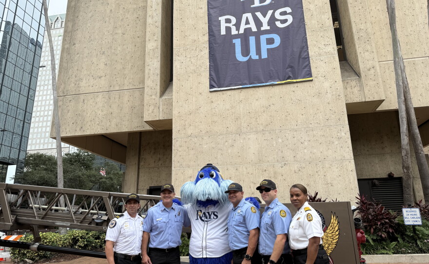 The Tampa Bay Rays' mascot, Raymond, poses with Tampa Fire Rescue's Truck 9 firefighters and paramedics and Fire Chief Barbara Tripp (right). Macho Barrios, a fourth-generation Tampa resident and long-time Rays fan, stands to the right of Raymond.