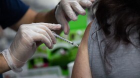 A pharmacist administers a third dose of the Moderna COVID-19 vaccine. (Emily Elconin/Getty Images)