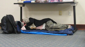  A woman clutches a stuffed bear at a temporary warming shelter at the Ashland Public Library Tuesday night.