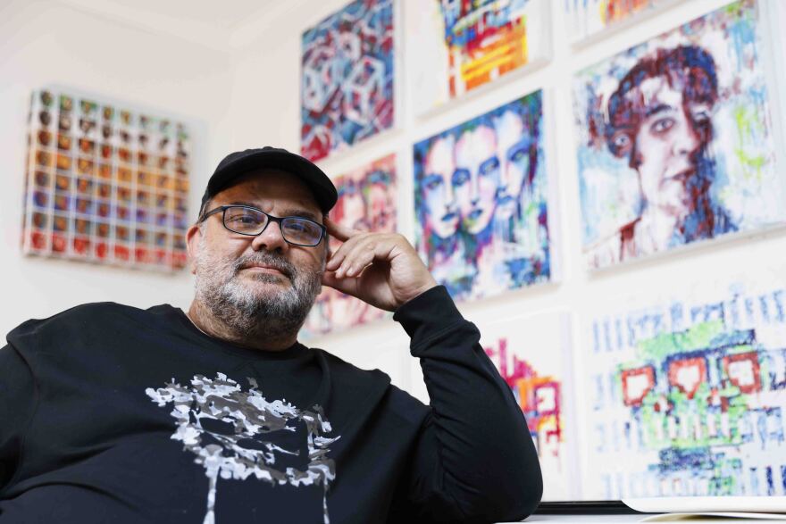 Pindar Van Arman sits next to his artwork. 