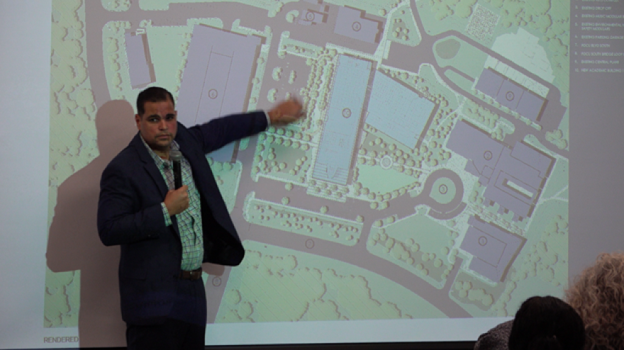 Miguel Rodriguez-Aquino, Project Manager II at FGCU, pointing at a map of FGCU showing where the new Academic Building 10 will be located.