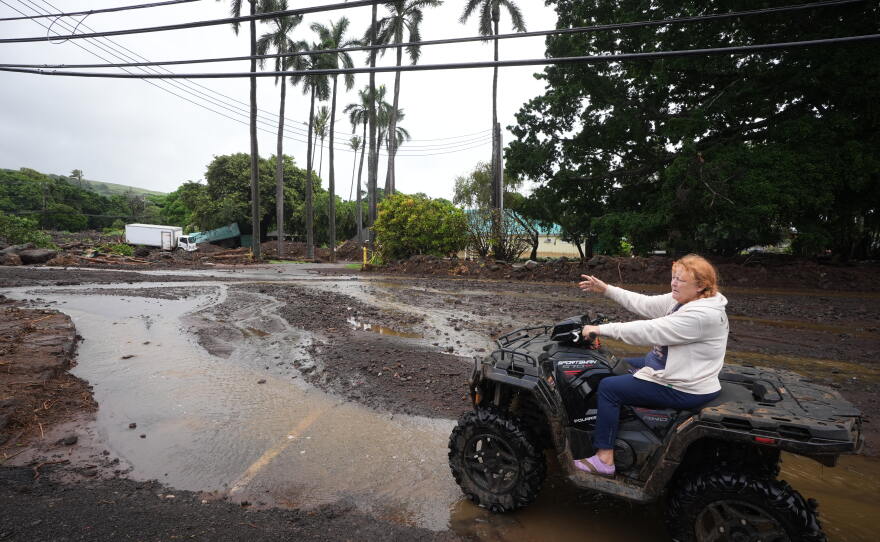 Peggy McKibbin looks at where floodwaters from nearby Hurricane Nolo run past widespread damage from last month's Hurricane Lala Sunday, Sept. 27, 2026, in Nāʻālehu, Hawaiʻi.