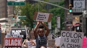 A little girl holds up a sign as "Black Lives Matter" New York protesters demonstrate in Times Square over the death of George Floyd by a Minneapolis police officer. (Bryan R. Smith/AFP/Getty Images)