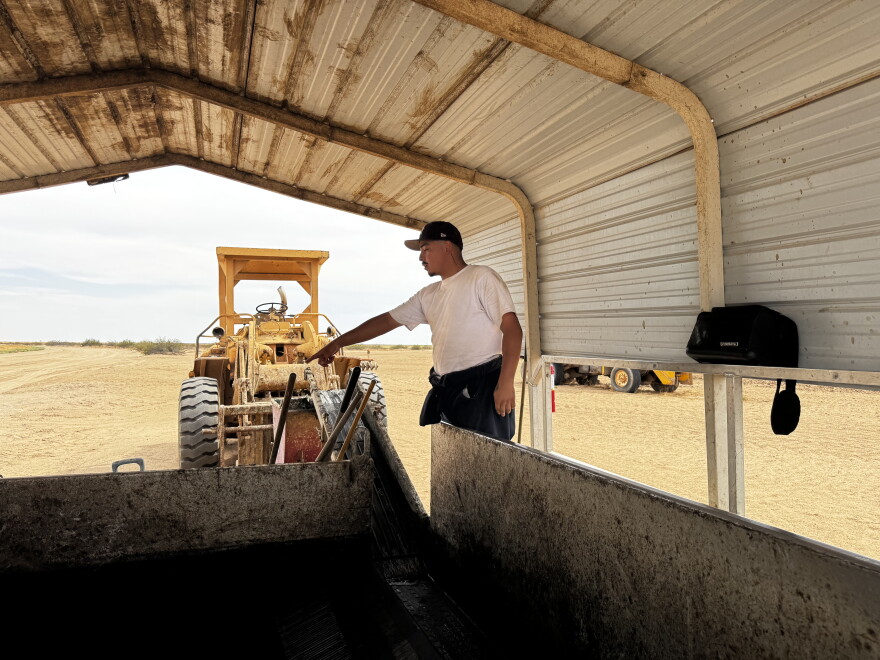 AgTech worker indicating and explaining about biosolids transfers from truck to operation.