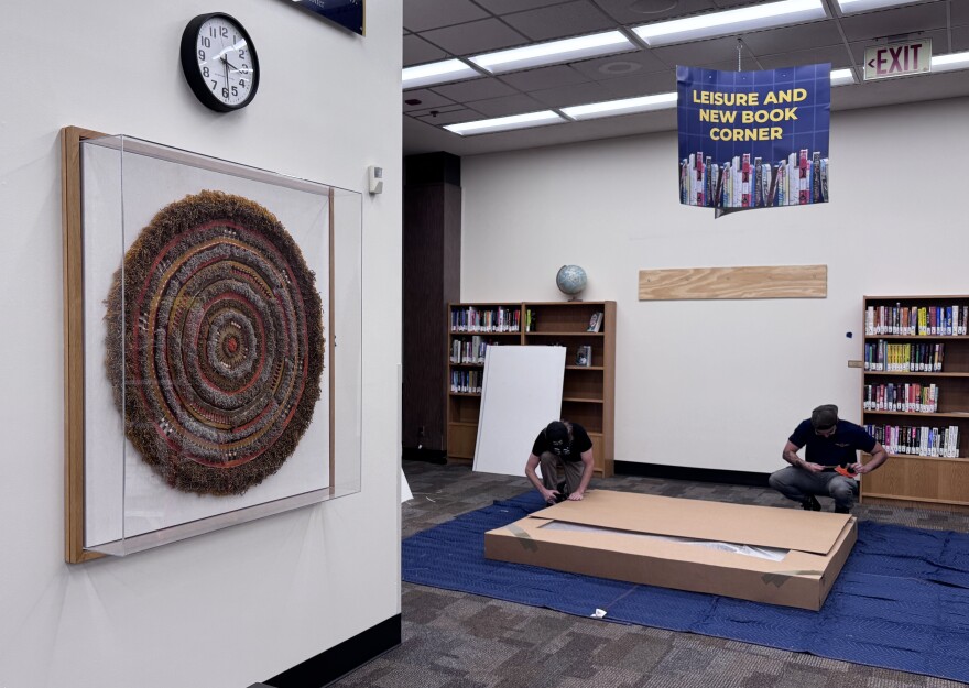 "Sunburst" by Melanie Vandenbos hangs on the wall of the University of Central Oklahoma's Chambers Library while art movers pack up another piece of the Murrah Collection on June 24, 2026.