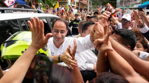 A man greets a crowd of supporters during campaign rally 