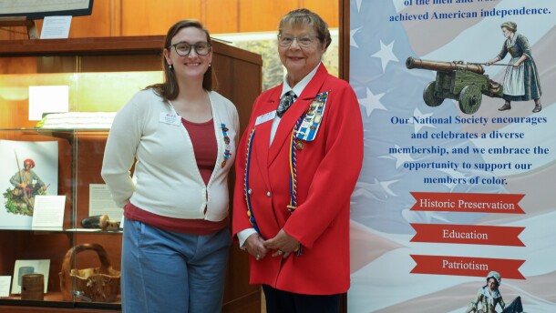 Brianna O'Shea, who leads the local Daughters of the American Revolution "E Pluribus Unum Educational Initiative," left, and Phyllis Breen, regent of the Irondequoit Chapter of the Daughters of the American Revolution, stand beside an exhibit exploring Rochester's connections to the American Revolution and its legacy. The exhibit features original artifacts from the New York State Museum and local collections and is presented by the Office of Rochester & Monroe County History, the Irondequoit Chapter of the Daughters of the American Revolution, and the Sons of the American Revolution.