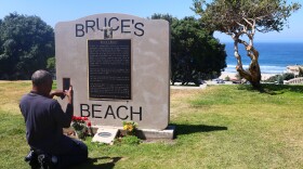 William Redmond III, a visitor from Atlanta, takes a photo of the historic plaque marking Bruce's Beach in April in Manhattan Beach, Calif.