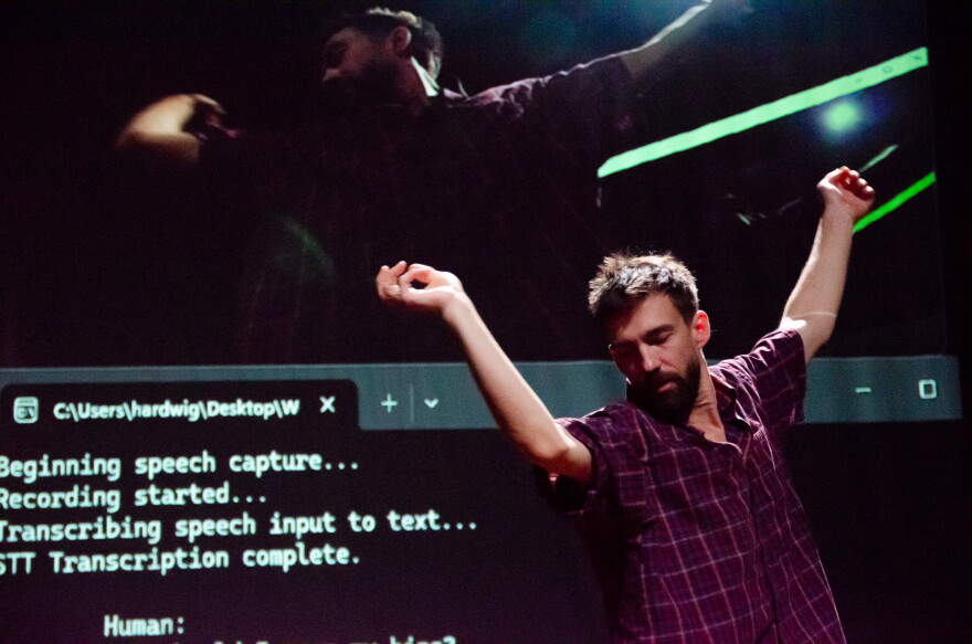 A man in a red plaid shirt sways and dances with his eyes closed, as a screen behind him reads "Beginning speech capture. Recording started. transcribing speech input to text."