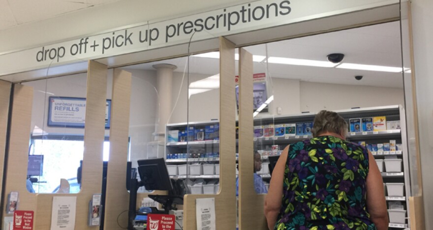 A customer picks up her prescription at the pharmacy counter inside Walgreens at 1400 E. Second St. in Edmond.