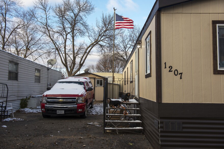 Rusty Welton's two dachshunds sit on the steps to his home. Some residents like Welton are not active participants in the cooperative, which can lead to heavier workloads for other residents.