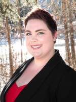 Kelley DiPasquale smiles while posed in a snowy forest. 